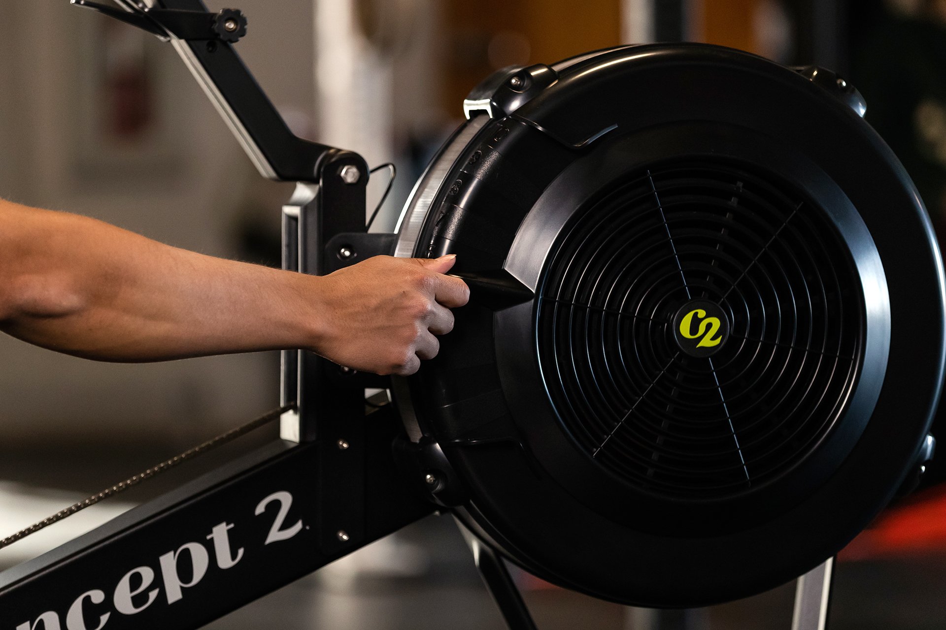 Hand reaching out to change the damper setting on a RowErg Flywheel