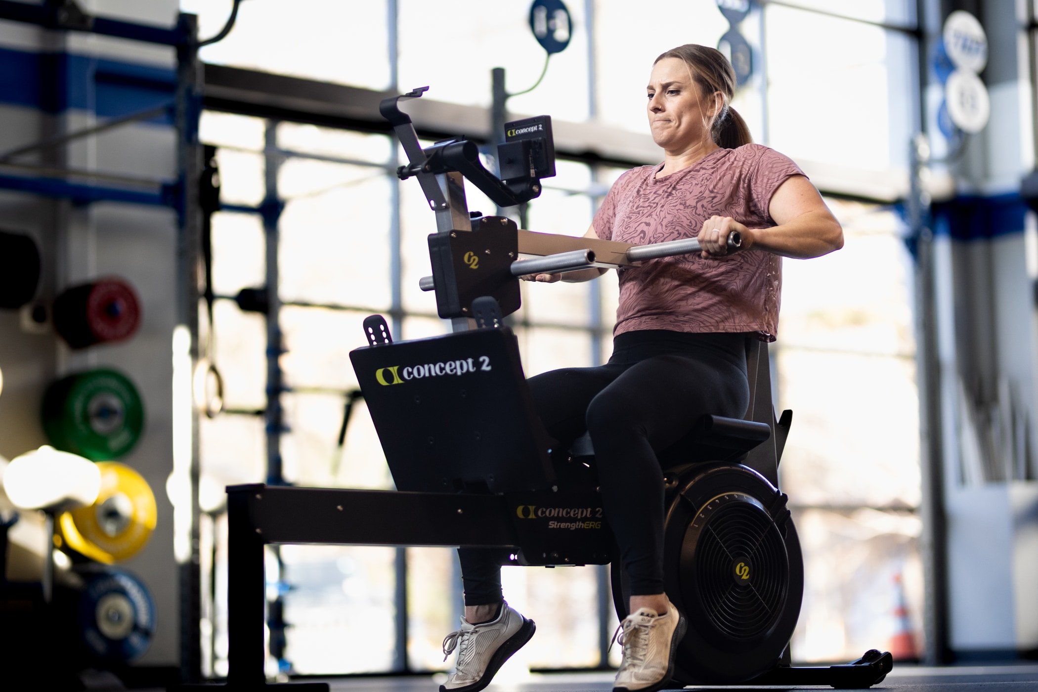 Woman in gym doing chest press on StrengthErg