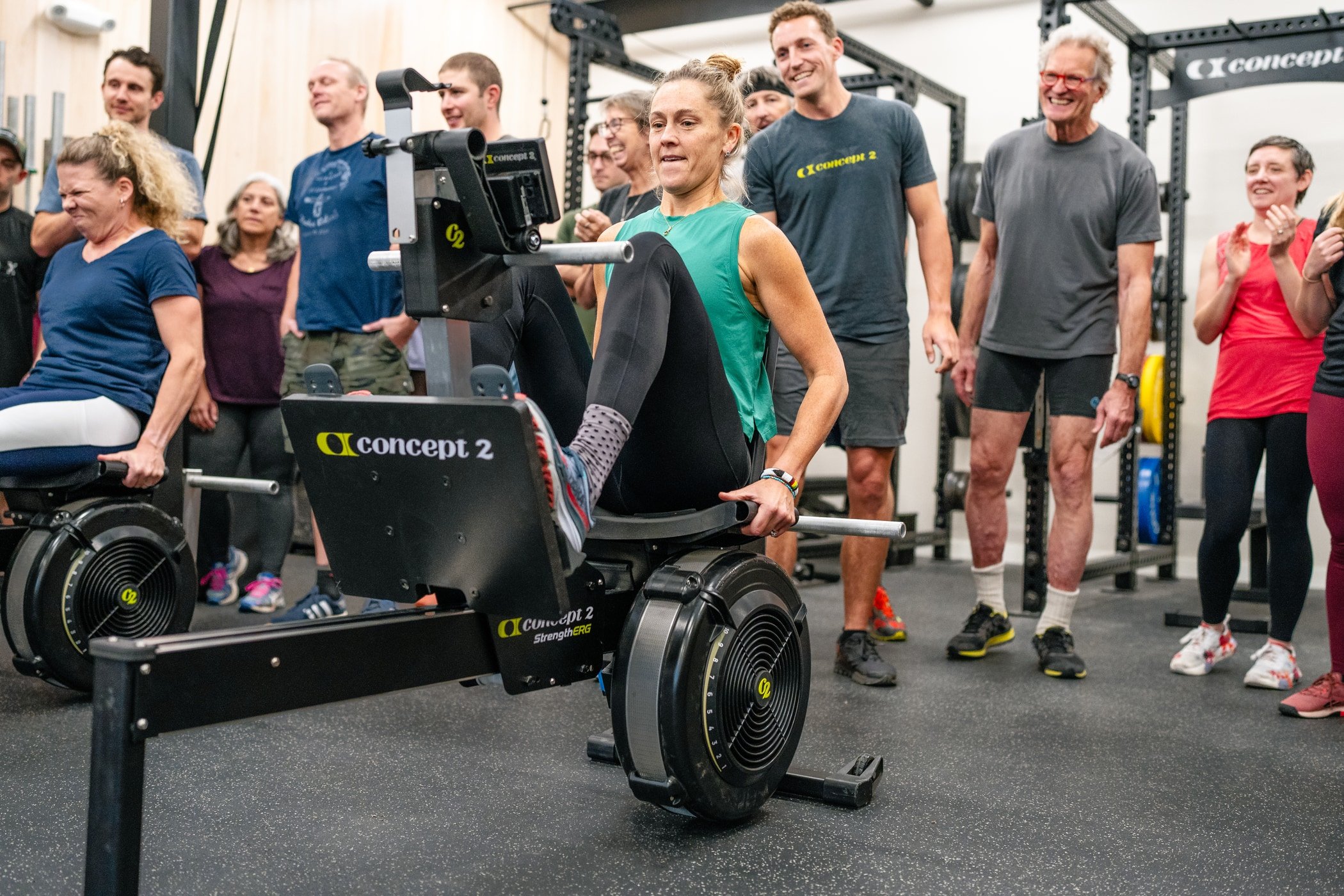 Woman doing leg press on StrengthErg while people stand around supporting